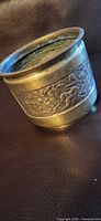 Overall view of brass planter with embossed floral band