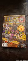 Front of Luxor 2 retail box showing artwork and compatibility icons