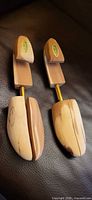 Full view of both cedar shoe trees on leather surface