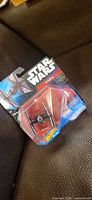 Sealed Hot Wheels Star Wars First Order TIE Fighter blister pack on leather surface