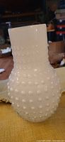 Full view of white hobnail glass vase standing upright