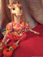 Giraffe figurine seated, showing costume detail