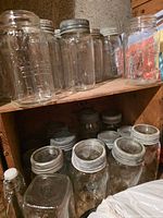 Upper and lower shelf showing various quart-size jars with metal lids