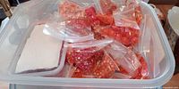 Tub with multiple zip bags of red and orange beads