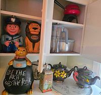 Overview of cookie jars, Brita pitcher, floral teapots, Droste tin inside cabinet and on counter