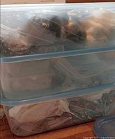 Stacked clear plastic storage bins filled with bagged chandelier parts