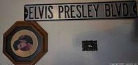 Framed Elvis Presley gold record style plate with metal Elvis Presley Blvd. sign on wall