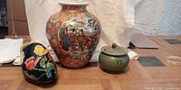 Group shot of vase, lidded jar and painted wooden shoe