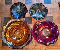 Top-view of five Fenton carnival glass pieces showing color variety and patterns