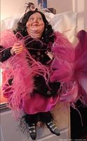 Full view of doll showing outfit, feather boa, overall size