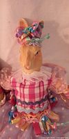 Close-up of rabbit with pink plaid bodice and ribbon hat