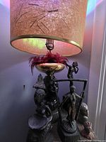 Lamp with fiberglass shade and surrounding metal sculptures