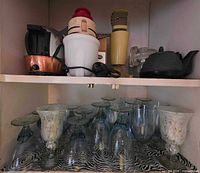 Shelf showing small appliances and teapot