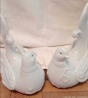 Front view of both glossy white ceramic bird figurines showing size and matching design
