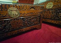 Close view of carved front panels, brass lock plate and motifs on both chests
