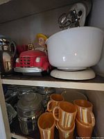 Shelf view showing hand mixer with bowl and cookie jar