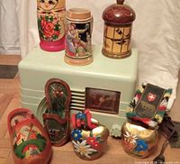 Overview of lot showing radio, clogs, cowbells, heart bells and wooden trinket boxes