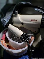 Mixer head with Sunbeam logo, partial view of bowl and beaters