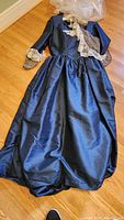Blue Victorian style gown laid on floor showing full length and fabric