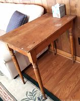 Full view of pine side table against wall