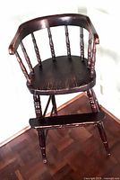 Full view of antique child’s high chair showing overall design and dark finish