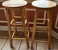 Two blond wood bar stools side by side