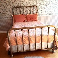 Brass bed assembled with mattress and bedding, showing headboard, footboard, side rails