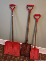 All three shovels leaning against wall for size and condition overview