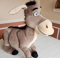 Full view of 24" grey donkey plush toy standing on table