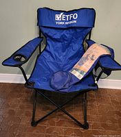 Front view of blue ETFO York Region folding camp chair with bag placed on seat