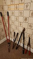 All five garden trimming tools leaning against wall