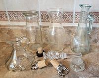 All four cruets/decanters and five stoppers on countertop
