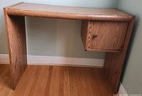 Full view of oak desk against wall, shows overall shape
