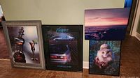 Group shot of four framed posters leaning against wall
