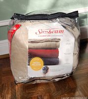 Blanket in clear zippered storage bag showing Sunbeam label