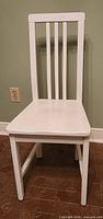 Front view of white wooden slat-back chair