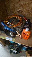Shelf with jumper cables, extension cord, car polish bottles