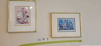 Two framed watercolour prints on wall