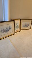 Three framed prints leaning against wall showing size and matching frames