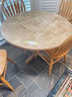 Top view of round wood table showing parquet pattern and pedestal base
