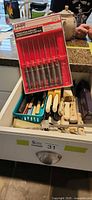 Drawer view with assorted knives, sealed Laser steak knife set on top