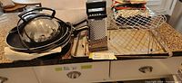 Stack of non-stick cookware, grater, wire racks and tray