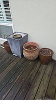 Group shot of four planters on deck against wall