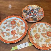 Three decorative porcelain plates on table