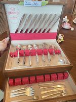 Full view of open chest showing knives, forks, spoons and lower drawer