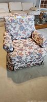 Front view of floral upholstered swivel armchair