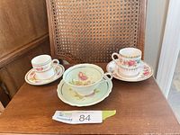 Three teacup and saucer sets displayed