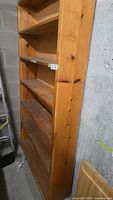 Full view of wooden 5-shelf bookcase against wall