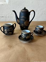 Full tea set showing teapot, sugar bowl, two teacups with saucers