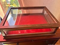Top view of wooden framed glass display case on red surface